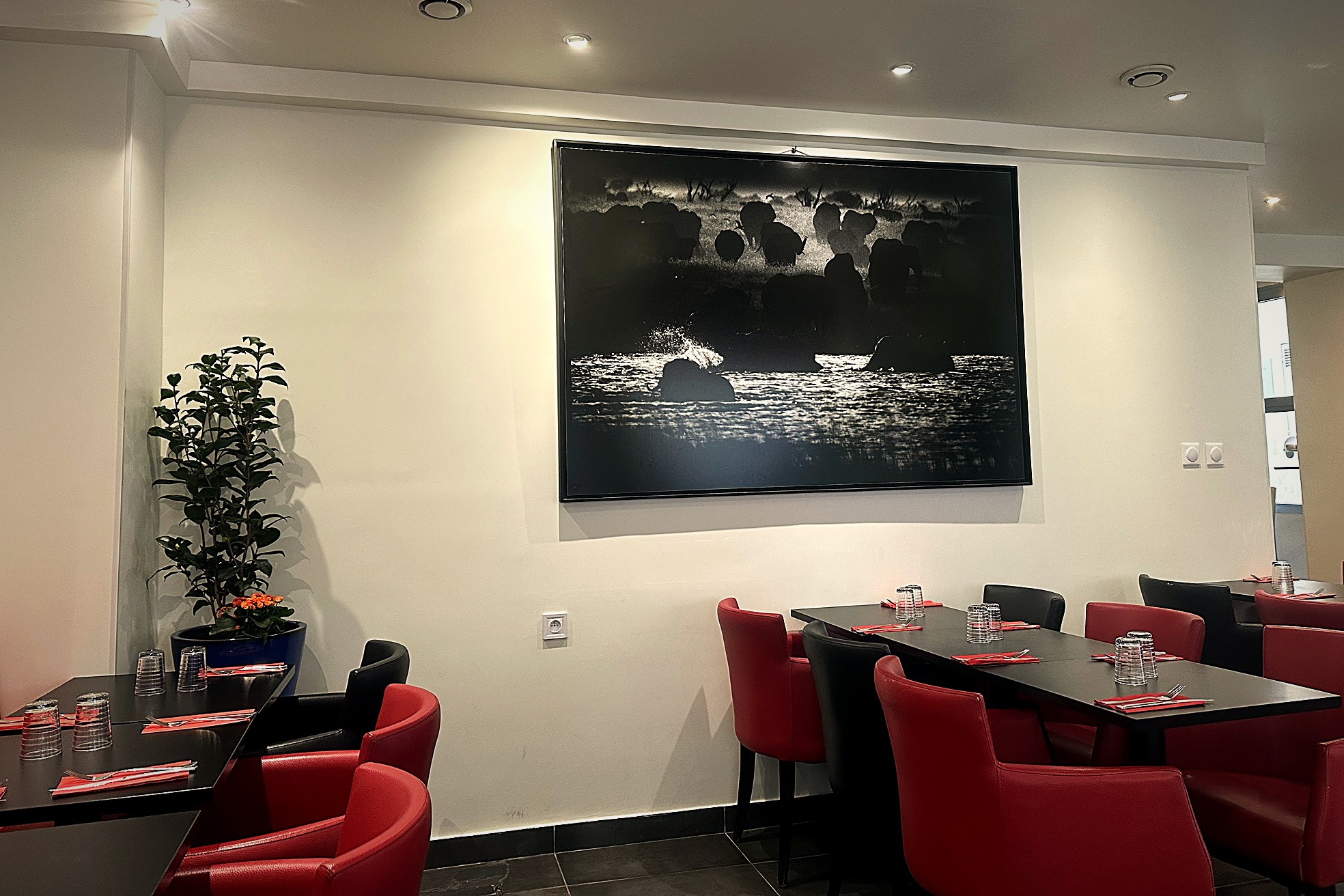 Salle du restaurant ZAMA à Paris 14e, avec banquettes rouges et tables noires