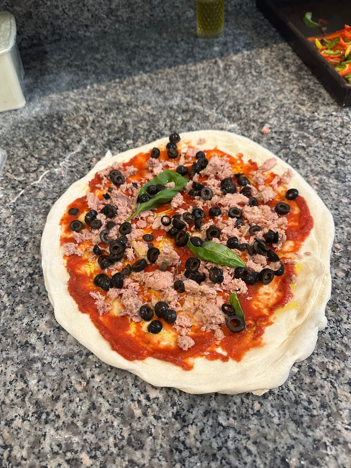 Pizza au thon et aux olives noires avant sa cuisson au feu de bois chez ZAMA